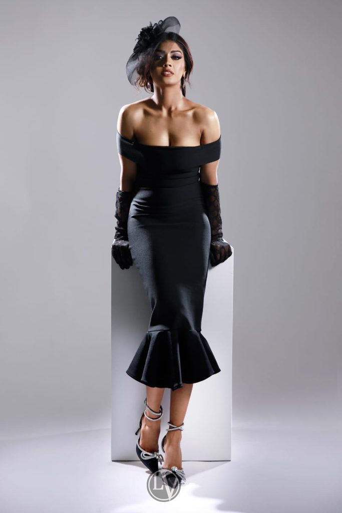 Sabrina elegantly displays her long legs, beautifully complementing her stylish outfit.